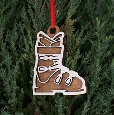 a wooden ornament hanging from a tree with a shoe on it's side