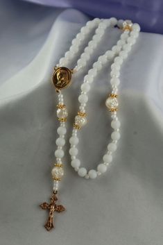 Handmade rosary made of artificial pearls With intermediate pearls in rose look Golden Cross Medallion with Mary and merciful Jesus in gold Ideal for baptism or first communion Affordable White Beaded Rosary Bracelet, Elegant Cheap Rosary Bracelet For Women, Cheap First Communion Rosary With 8mm Beads, Elegant Pearl Rosary With 8mm Beads, Elegant Round Beads Rosary For First Communion, Elegant Rosary Bracelet With Round Beads For First Communion, Elegant Rosary Bracelet For First Communion With Round Beads, Elegant Pearl White Rosary With Round Beads, Elegant White Rosary For First Communion