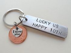 a keychain with a penny on it that says lucky us happy 10th