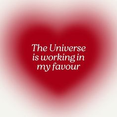 the universe is working in my favour quote on red and white blurred background