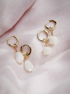 The Lei Hoops reflect Hawaii's natural abundance and beauty. These small gold mother of pearl and gold huggie hoop earrings feature darling carved seashell flower charms reminiscent of Hawai'i's flower leis. These pretty gold hoops are perfect solo or teamed with our some huggie hoops.Handmade on Maui, Hawaii. ✦ Choose from two flower styles: Tulip or Pikake ✦✦ DETAILS ✦✧ Name: Lei (LAEE) - garland.✧ 18kt Gold Vermeil.✧ 25mm & 29mm Drop Length✧ 12mm hoop outer diameter, 9mm inner diameter, & 2.5 White 14k Gold Filled Huggie Earrings, Flower Charm Huggie Earrings As Gift, Gift Jewelry Flower Charm Huggie, Huggie Jewelry With Flower Charm For Gift, Huggie Jewelry With Flower Charm As Gift, Dainty White 14k Gold Filled Huggie Earrings, Delicate Pearl Charm Huggie Jewelry, White Pearl Charm Dangle Huggie Earrings, Delicate Handmade Huggie Earrings