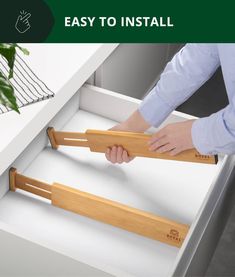 a person is opening the drawer with two wooden handles