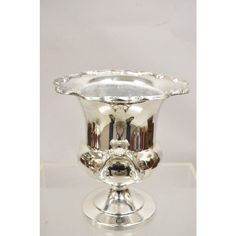 a silver vase sitting on top of a white table