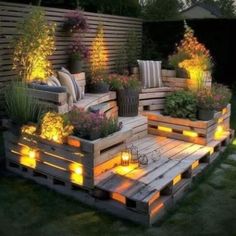 a wooden pallet filled with lots of plants and lit up lights on top of it