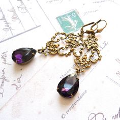 Purple victorian dangle earrings made of purple crystal faceted teardrop drops set in oxidized brass settings and a beautiful oxidized brass ornament. The earwires are made of oxidized brass. The length of the earrings including the hook is approximately 7 cm. (2.8 inches) Crystal: 13 x 18 mm. The oxidized brass components are made in the USA, most pieces are stampings made of antique dies from the 19th century. They are oxidized for a lovely antique bronze patina and durability. For more jewelr Brass Ornament, Brass Components, Victorian Earrings, Brass Ornaments, Oxidized Brass, Bronze Patina, Earrings Purple, Purple Rhinestone, Purple Crystal