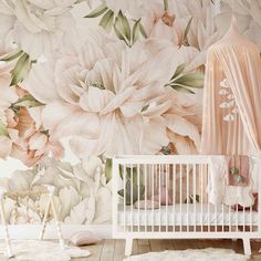 a baby's room decorated in pink and white with large flowers on the wall