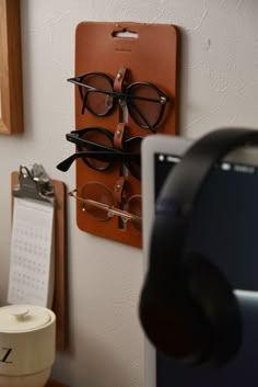 a pair of glasses is hanging on the wall next to a phone and headphones