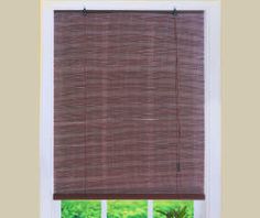 a window with a brown roman blind in front of it and a potted plant on the windowsill