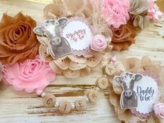 some pink and brown flowers are on a wooden table next to the nameplates