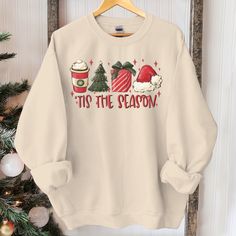 a white sweatshirt that says tis the season on it