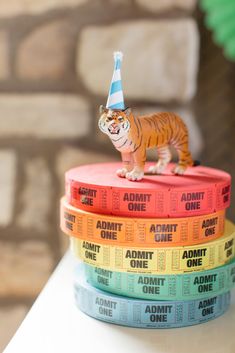 there is a small tiger figurine sitting on top of three stacks of books