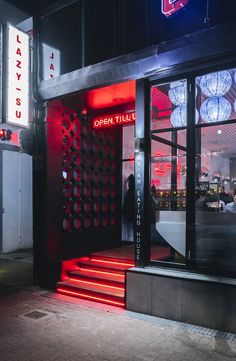 the entrance to an open tile store with red steps leading up to it's doors