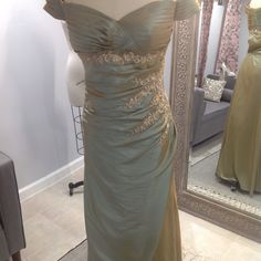 Elegant And Comfortable Soft Iridescent Taffeta Gown In Aqua Gold. Gown Is Accepted With Gold Toned Appliqu And Delicate Beading. Satin Floor-length Mother Of The Bride Dress For Gala, Floor-length Satin Mother Of The Bride Dress For Gala, Satin Floor-length Dress For Mother Of The Bride, Gala Mother Of The Bride Dress With Ruched Bodice, Formal Satin Ball Gown For Mother Of The Bride, Formal Mother Of The Bride Dress With Ruched Bodice, Satin Floor-length Gown For Mother Of The Bride, Elegant Embellished Satin Mother Of The Bride Dress, Elegant Satin Gown For Mother Of The Bride