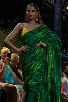 Upgrade your ethnic elegance with our Gia Green & Yellow Tie Dye Georgette Silk One Minute Saree. Crafted from luxurious raw silk, this stunning saree features a mesmerizing green-yellow tie-dye pattern. The pallu is adorned with vibrant yellow tassels, while the matching blouse comes with delicate spaghetti straps in yellow raw silk, adding a touch of sophistication to your traditional attire. Suitable for a summer night out, wedding party, pooja or any other function! About this Product Saree: Green Chanderi Pre-draped Saree For Festivals, Green Chanderi Pre-draped Saree For Puja, Transitional Green Pre-draped Saree With Self Design, Green Raw Silk Pre-draped Saree With Self Design, Green Tussar Silk Pre-draped Saree With Dupatta, Designer Green Saree For Transitional Season, Green Slub Silk Pre-draped Saree For Diwali, Designer Transitional Green Saree, Designer Green Tissue Silk Blouse Piece