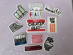 a bunch of stickers that are on top of a purple surface with white and black writing