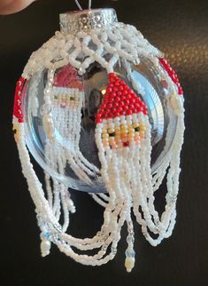 a christmas ornament made out of beads and beadwork with a santa clause on it