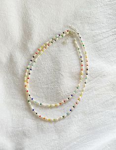 ∙ MINIMAL ∙ PEARL ∙ NECKLACE∙ Freshwater pearls are naturally unique in colour, shape, and texture so may differ slightly from those pictured.  ∙ APPROXIMATE ∙ MEASUREMENTS ∙ Each necklace comes with an additional 2 inch extension chain on top of your selected length.   For example, if you select the 14 inch necklace option, the total length of the necklace will be 16 inches including the clasp and extension chain. ∙ MATERIALS ∙  Strong steel cord, genuine freshwater pearls, coloured glass beads, silver plated or sterling silver clasp and extension chain. ∙ CARE ∙ INSTRUCTIONS ∙ The colour on silver plated or sterling silver jewellery may fade over time if it is not properly taken care of. To ensure it stays in perfect condition: 1. Remove before coming into contact with water (e.g. swimmi Dainty White Double Strand Pearl Necklace, White Double Strand Pearl Charm Beaded Necklace, White Double Strand Beaded Necklace With Pearl Charm, Adjustable Multicolor Beaded Necklace With Pearl Charm, White Double Strand Pearl Beaded Necklace, White Multi-strand Beaded Necklace With Tiny Beads, Colorful Multi-strand Pearl Beaded Necklaces, Multicolor Pearl Beaded Necklace With Pearl Chain, White Beaded Choker Necklace With Pearl Charm