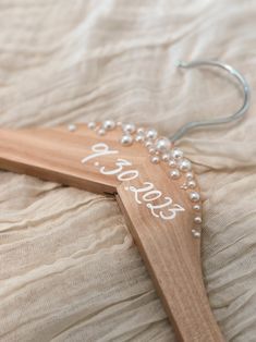 a wooden hanger with beaded writing on it