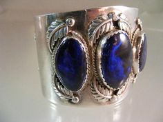 "An absolutely outstanding vintage Southwest Cuff bracelet in Sterling Silver featuring three Museum Quality Banded Azurite Cabochons, which are more than likely from the Bisbee Mine. You know you have exceptional stones in jewelry when the smith adds the carat weight on the interior of the piece, and that is what we have here; marked 65cts, etched into the interior of the bracelet. The center Azurite measures 28mm x 18.5mm. The side stones measure 25mm x 15mm and 23mm x 15mm. I have photographe Blue Oval Vintage Cuff Bracelet, Vintage Cabochon Cuff Bangle, Vintage Blue Cuff Jewelry, Navajo Art, The Smith, Three Stone, Vintage Signs, Cuff Bracelet, Cuff Bracelets