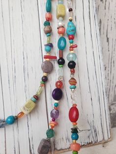 "Three stunning graduated strands of multi color, semi precious stones make up this long bold necklace. Just about every stone you can imagine; turquoise, garnet, lapis, pearl, chrysoprase, red coral, and carnelian, just to name a few. The stones are accented with Bali sterling silver fancy spacers. The longest strand measures 33\", the middle strand measures 30\" and the shortest strand measures 27\". All three strands are connected with a sterling silver lobster clasp. It is hand strung on a 4 Multicolor Gemstone Beads Lariat Necklace, Multicolor Multi-strand Necklace For Healing, Multicolor Lariat Necklace With Gemstone Beads, Multicolor Turquoise Gemstone Necklace With Round Beads, Unique Multicolor Beaded Turquoise Necklace, Unique Multicolor Turquoise Necklace With Colorful Beads, Multicolor Turquoise Gemstone Necklace, Hippie Style Multicolor Long Necklace, Multicolor Multi-strand Necklaces With Natural Stones