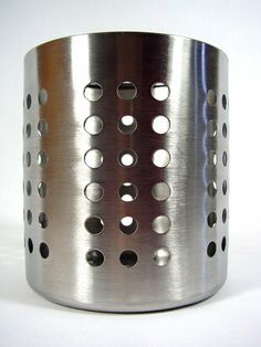 a metal cup holder with holes on the bottom and sides, sitting on a white surface