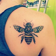 a woman with a bee tattoo on her shoulder