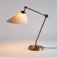 a lamp that is on top of a white surface with a cord attached to it