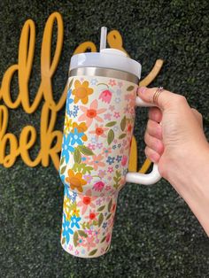 a person holding a coffee cup in front of a sign