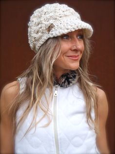 a woman with long hair wearing a white knitted hat and smiling at the camera