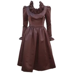 Jill Richards, the California designer of this fabulous 1970's cocktail dress, had the well earned nickname of 'Ruffles Richards' with both a flair for drama and flattering silhouettes. The dress is fabricated from a rich chocolate brown satin fabric which is expertly cut to provide a fitted torso yielding to a voluminous skirt featuring hidden side pockets (love a hidden pockets in cocktail wear!). The lovely sleeves provide a gentle pouff at the shoulder with a skinny fit to the ruffled cuff.