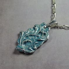 "PENDANT SIZE:  Turquoise blue acrylic paint and clear gloss. Made of lead-free solder,  1\" x 3/4\" oval shaped.   CHAIN:  Adjustable length up to 18\", silver plated chain and lobster clasp."