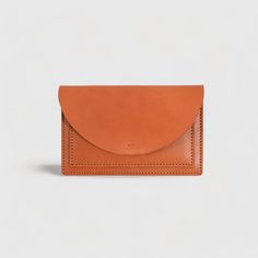 "Slim and simple, this women's wallet holds all your essentials. Designed to fit an iphone, credit cards and bills. Made from high quality full-grain leather, this accessory has been oiled and waxed to make sure it ages beautifully and lasts a lifetime. With a minimal design and hidden snap button, this wallet is truly a timeless piece that will age and create beautiful patina with time. Features: * 1 large compartment for cellphone or make-up or other essentials * 2 exterior credit card pocket that will fit up to 6 cards each * 2 interior credit card pocket that will fit up to 6 cards each * Hidden snap closure * Full-grain English Bridle leather * Vegetable tanned  in the US Dimensions: 4\" x 8\"" Modern Leather Clutch With Cell Phone Pocket, Rectangular Wallets With Waxed Finish For Everyday Use, Classic Leather Wallets With Cell Phone Pocket, Classic Leather Wallet With Cell Phone Pocket, Classic Leather Trifold Envelope Wallet, Minimalist Leather Clutch Wallet, Classic Brown Envelope Wallet, Everyday Leather Trifold Wallet With Cell Phone Pocket, Classic Clutch Wallet With Cell Phone Pocket