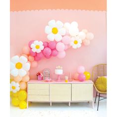 a room decorated with balloons and flowers on the wall, along with a dresser in front of it