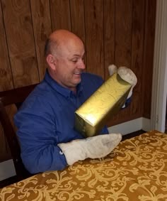 a man sitting at a table with a wrapped present