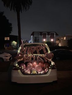 a car is decorated with balloons and happy new year's eve letters in the trunk