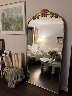 a large mirror sitting on top of a wooden floor