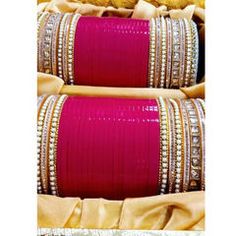 two rows of pink and gold bangles with white stones on each one, in front of a yellow background