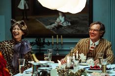 two people sitting at a dinner table laughing