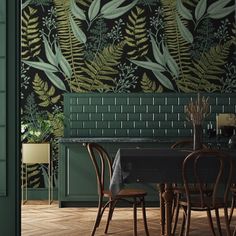 a dining room with green walls and wooden flooring that has plants on the wall