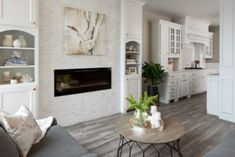 a living room filled with furniture and a fire place in the middle of a kitchen