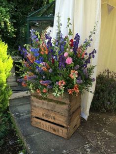 a wooden box filled with lots of flowers