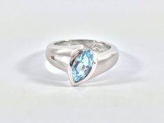 "Hi everyone, just wanted to let you know we are open and shipping daily. Beautifully crafted \"one of a kind\" contemporary Sterling Silver ring with genuine London Blue Topaz. The silver ring is finished with Rhodium so it will not tarnish. The gemstone used in this ring has been hand picked on a recent trip to Bangkok and is of a quality usually reserved for fine jewelry so you will almost never find such nice stones set in sterling silver! Weight 7.3 Grams This fine jewelry quality ring is p Modern White Gold Topaz Ring As Gift, Modern Sterling Silver Topaz Ring For Formal Occasions, Modern Silver Sapphire Ring With Accent Stones, Modern Silver Topaz Ring, Modern Topaz Promise Ring, Modern Blue Topaz Promise Ring, Modern Blue Topaz Ring With Tension Setting, Modern Topaz Ring With Polished Finish, Modern Sterling Silver Topaz Ring