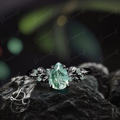 a green ring with leaves on it sitting on top of a black rock in the dark