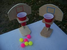 two plastic cups and some balls on a table