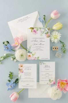 the wedding stationery is laid out with flowers