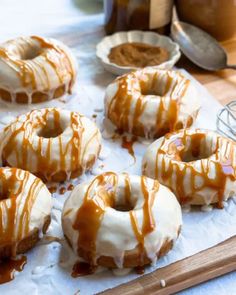 glazed donuts with caramel drizzle and icing on a cutting board