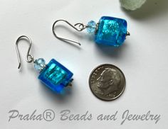 Perfect for any occasion. Simple, bright blue Murano glass square cubes drop from sterling silver ear wires. Swarovski crystals and rondells sit atop the beads. Silver foil is added inside the bright blue translucent glass beads. The beads measure 12MM. All sterling silver components. The length of the earring are just over 1 1/4" from the top of the handcrafted sterling silver ear wires. Nickel-free Rectangular Czech Glass Jewelry, Blue Earrings With Spacer Beads For Gift, Nickel Free Blue Rectangular Jewelry, Adjustable Blue Square Pendant Jewelry, Blue Square Earrings For Gift, Blue Beaded Rectangular Jewelry, Blue Rectangular Beaded Jewelry, Blue Square Sterling Silver Jewelry, Blue Hypoallergenic Glass Jewelry