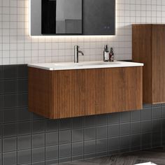 a bathroom with a sink, mirror and tiled walls