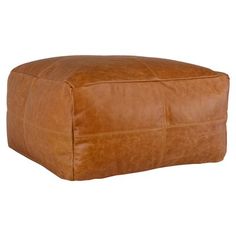 a brown leather ottoman sitting on top of a white floor