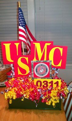 a wooden table topped with an american flag and a sign that says u s m c